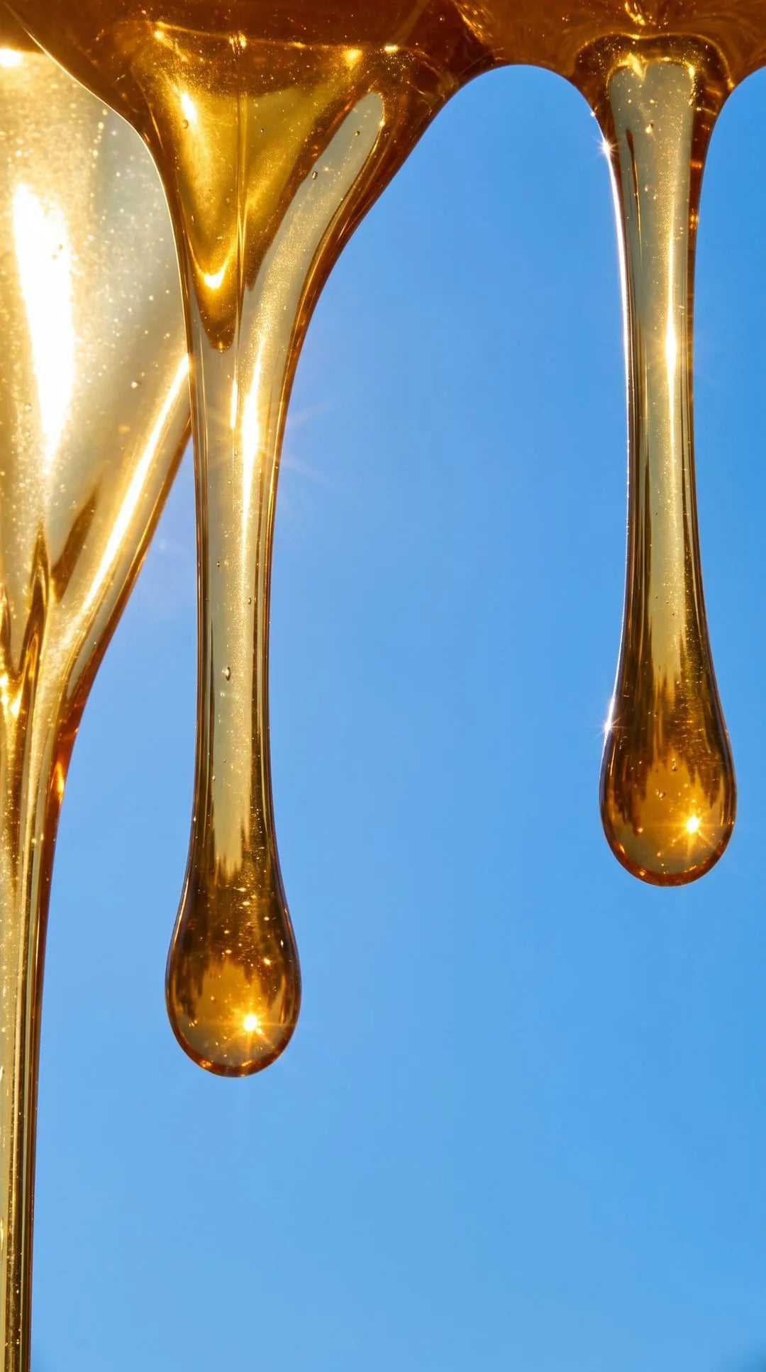 Honey dripping against a blue sky